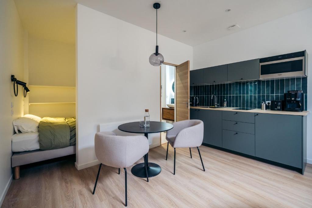 une cuisine et une salle à manger avec une table et des chaises dans l'établissement Le clocher du château, à Fontainebleau