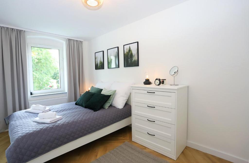 1 dormitorio con 1 cama y vestidor blanco en Apartament Między Wieżami, en Szczawno-Zdrój