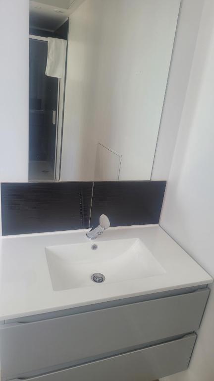 une salle de bain avec un lavabo et un miroir dans l'établissement Point central, à Tourcoing