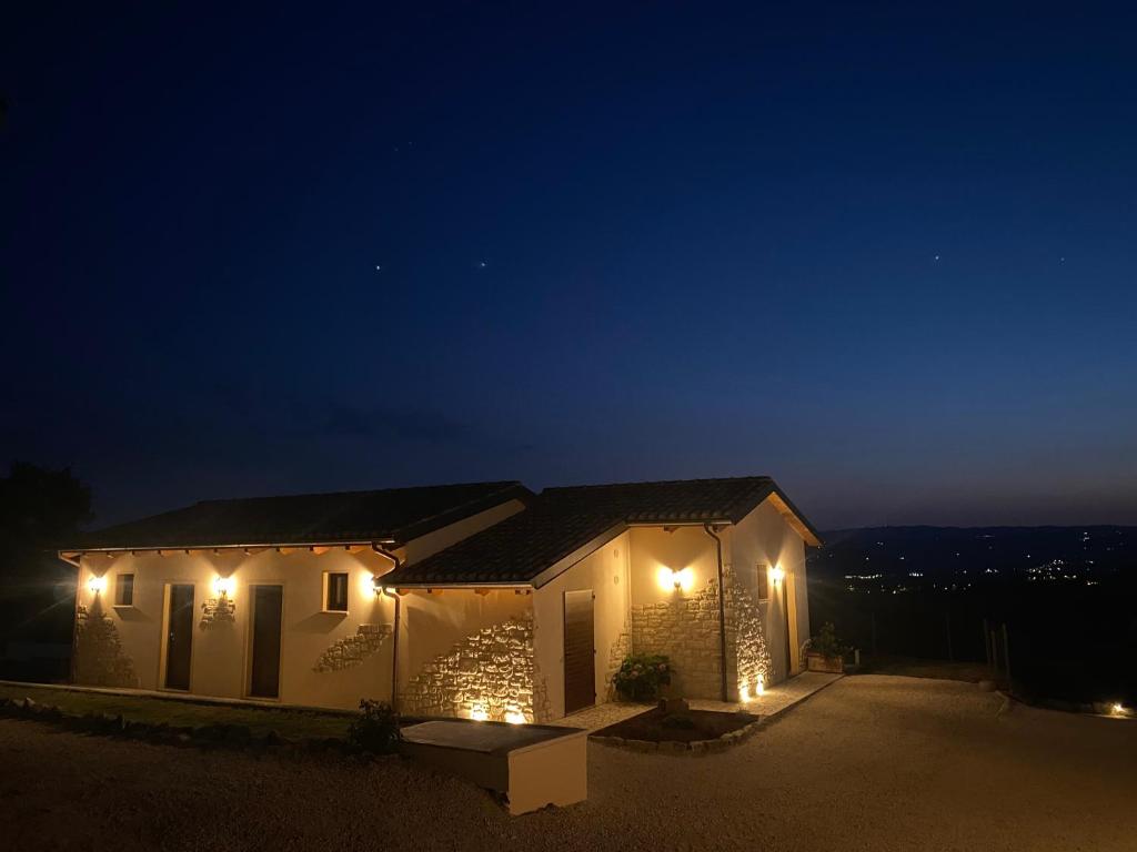 a house lit up at night with lights at Agriturismo La Quercia Bella in Frontignano