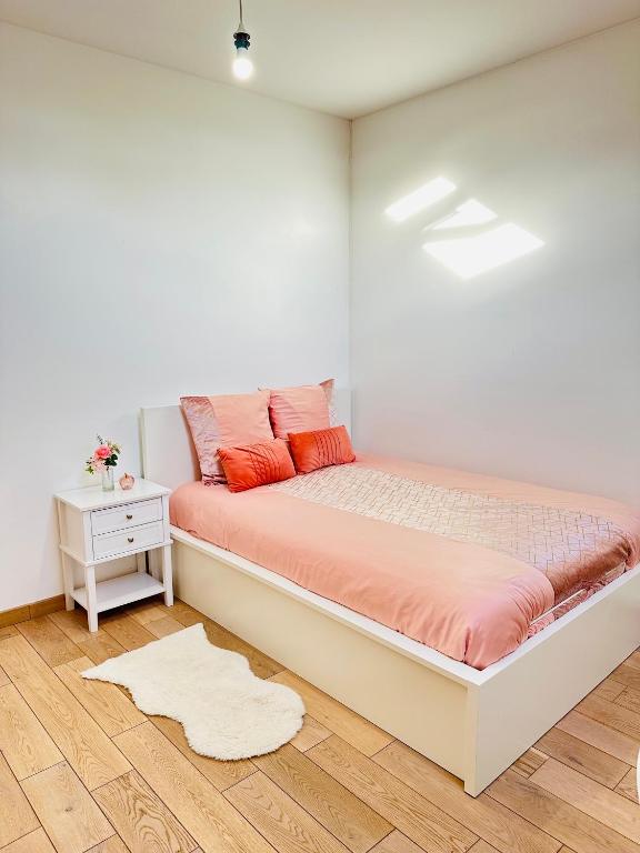 - une chambre blanche avec un lit et des oreillers orange dans l'établissement Jabeen's House Bedroom 2, à Bezons