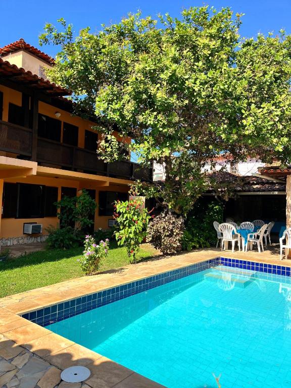 a swimming pool in front of a house at Calmaria Suítes Búzios in Búzios