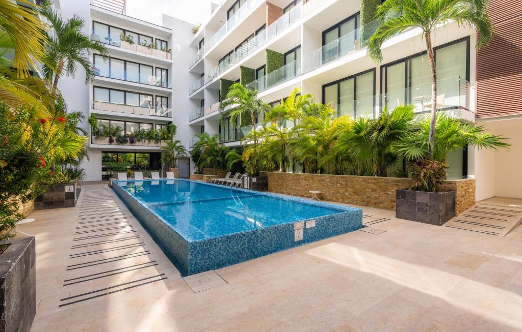 a swimming pool in front of a building at Tu Oasis en Playa del Carmen in Playa del Carmen