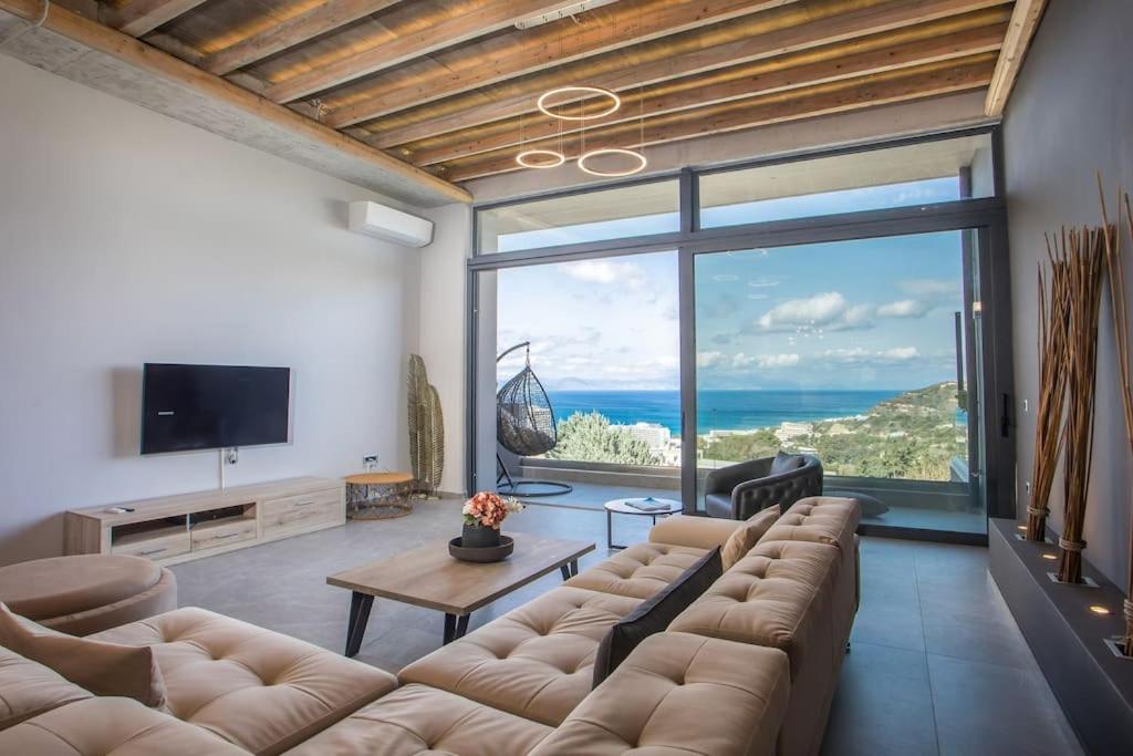 ein Wohnzimmer mit einem großen Sofa und einem großen Fenster in der Unterkunft Evie's Oasis in Ixia