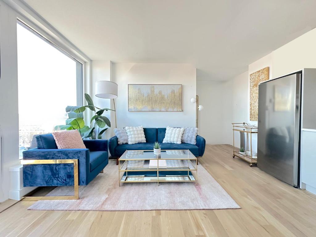 a living room with a blue couch and a table at Modern One Bedroom - Large Private Terrace - Luxury Building - Williamsburg in Brooklyn