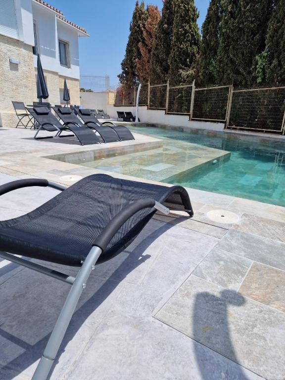 a lounge chair next to a swimming pool at Habitaciones independientes con baño - Villas Costa del Sol in Benajarafe