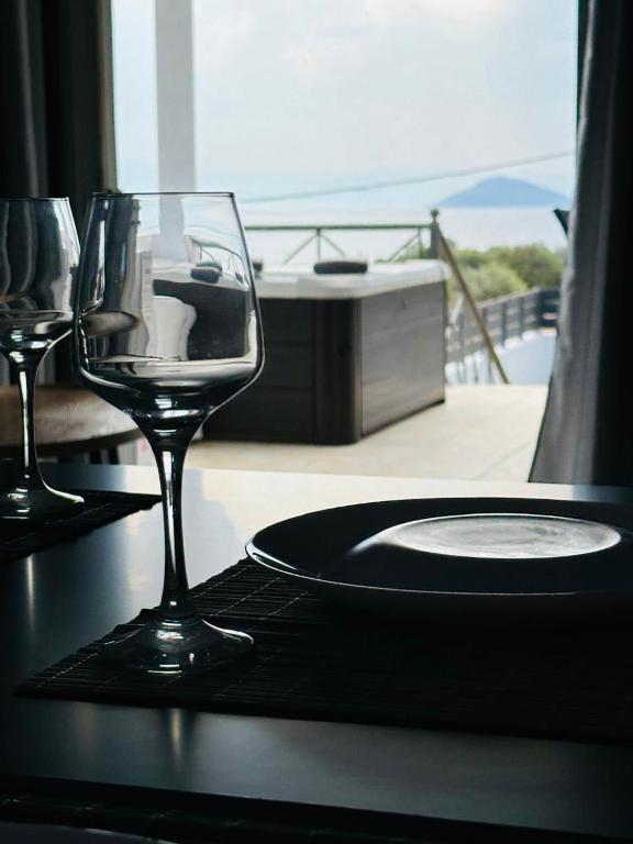 a wine glass sitting on a table with a plate at Saladi Beach House in Didyma