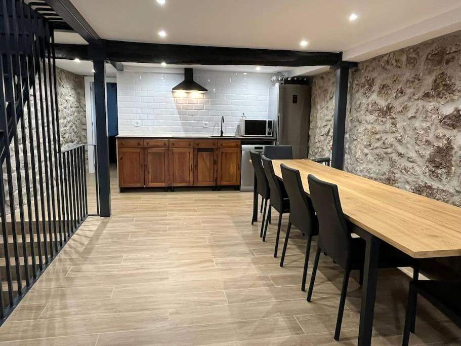 a dining room and kitchen with a wooden table and chairs at Casa rural Villa Cardil en la entrada del parque Cabarceno in Obregon