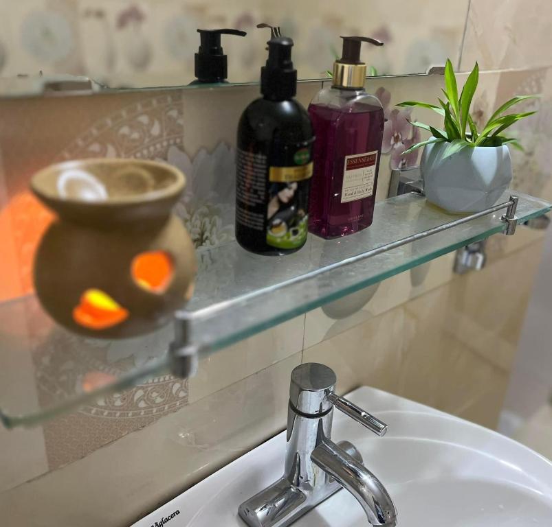 a bathroom sink with two bottles on a shelf at Na Tuệ An-Homestay Số 3 Hoàng Văn Thái in Tuyên Quang