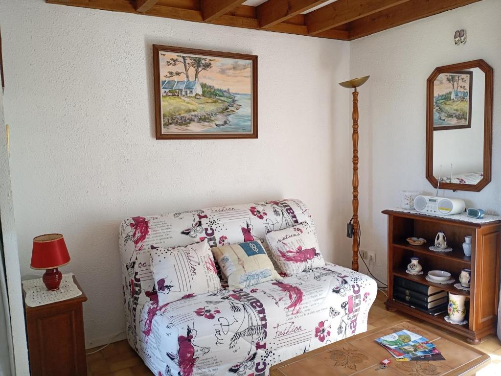 un salon avec un canapé et un miroir dans l'établissement Maison de vacances à 500m de la plage avec piscine, jardin et équipements inclus - FR-1-639-126, à Saint-Gildas-de-Rhuys