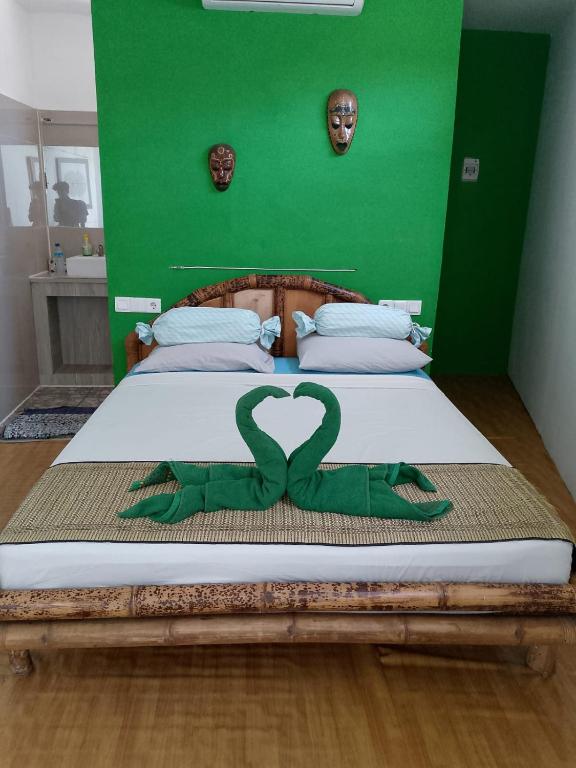 a bed with a heart made out of a green wall at WHITE SANDS RESORT in Gili Trawangan