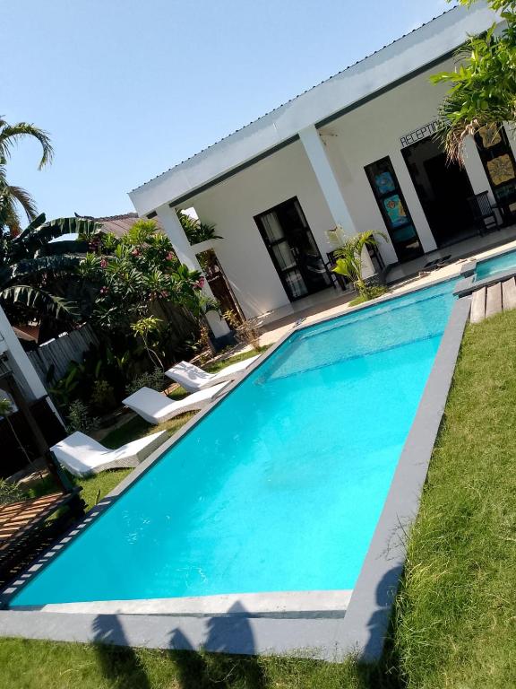 a swimming pool in front of a house at WHITE SANDS RESORT in Gili Trawangan