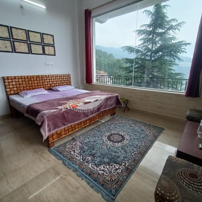 a bedroom with a bed and a large window at Swaran bnb near Mcleodganj in Dharamshala