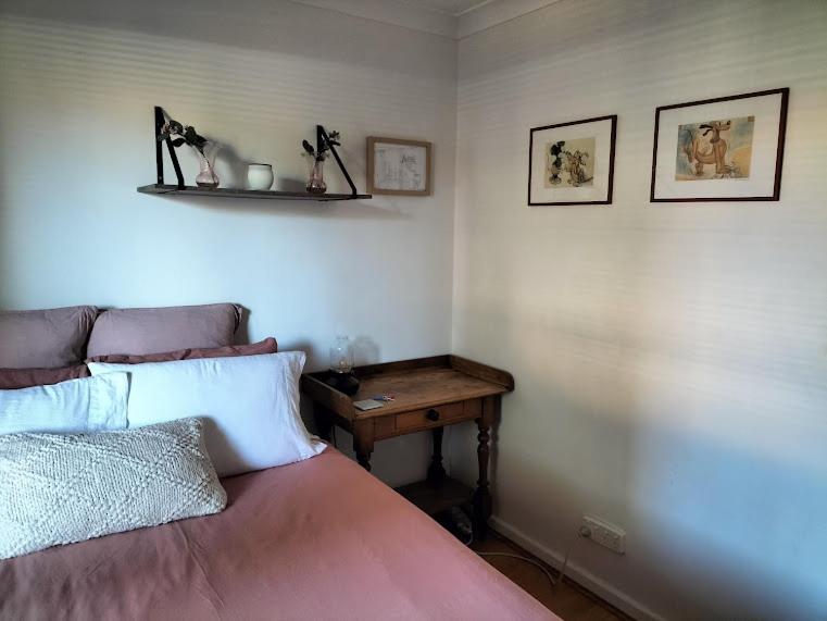 a bedroom with a bed and a wooden table at All the comforts by the lake in Perth