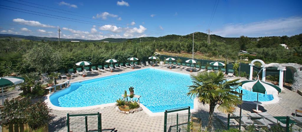 una vista aérea de una piscina con sillas y sombrillas en Villaggio Club Degli Ulivi en Vieste