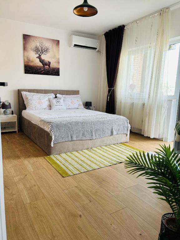 a bedroom with a bed and a large window at Cosy Nest Deva in Deva