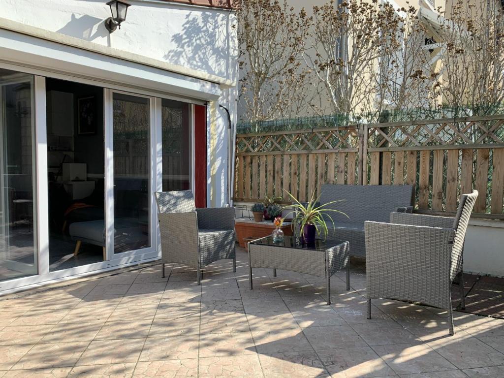 a patio with wicker chairs and a table at Little house 2 bedrooms -Terrace, Antony Center near Paris and Orly in Antony