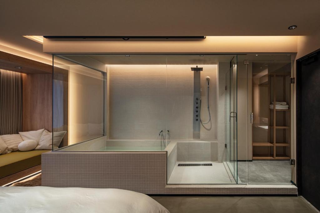 a glass shower with a tub in a bedroom at HotelCO Kuramae ホテル コ 蔵前 in Tokyo