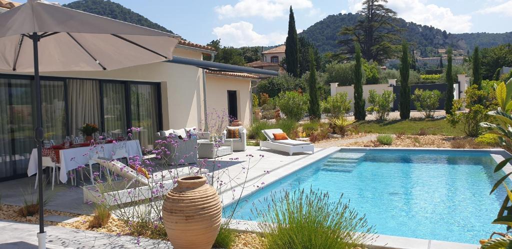 une villa avec une piscine et un parasol dans l'établissement Villa moderne avec jacuzzi, piscine et vue, à Séguret