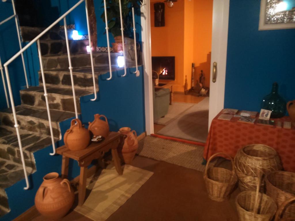 Habitación con escalera y jarrones sobre una mesa. en Casa Rural Pájaro Bobo, en Bustares