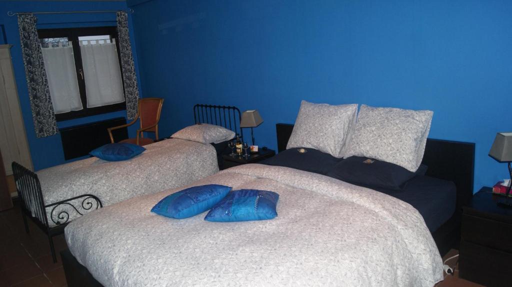 two beds in a blue room with blue walls at Fleurs-Sauvages in Hebronval