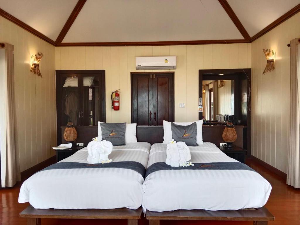 a bedroom with two large beds with towels on them at Koh Mook Sivalai Beach Resort in Ko Mook