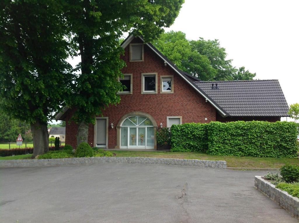 a red brick house with a driveway in front of it at Stapper's Landgasthaus Ferienwohnung in Ibbenbüren