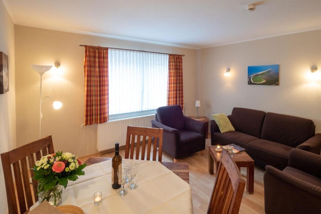 a living room with a table and a couch at Haus Seeschwalbe - Wohnung 07 in Spiekeroog