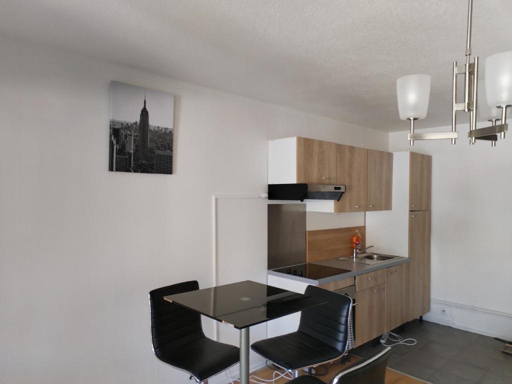 une cuisine avec une table et des chaises dans une pièce dans l'établissement Venez chez vous à Pessac, à Pessac