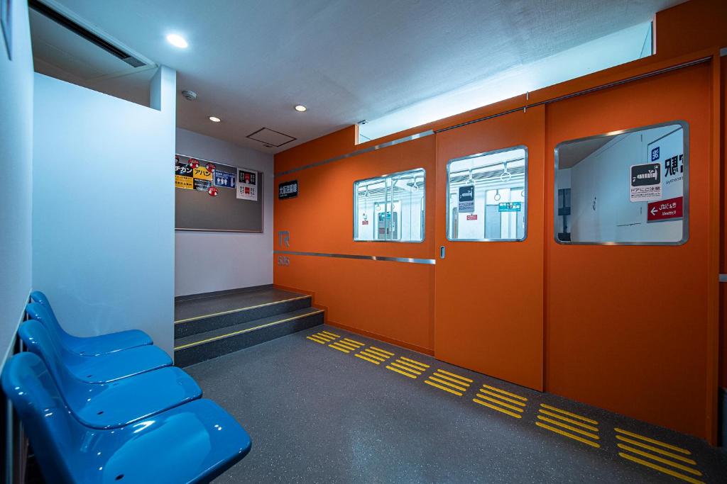 a waiting room with orange walls and a blue bench at Towers Hotel - Adult Only - in Osaka