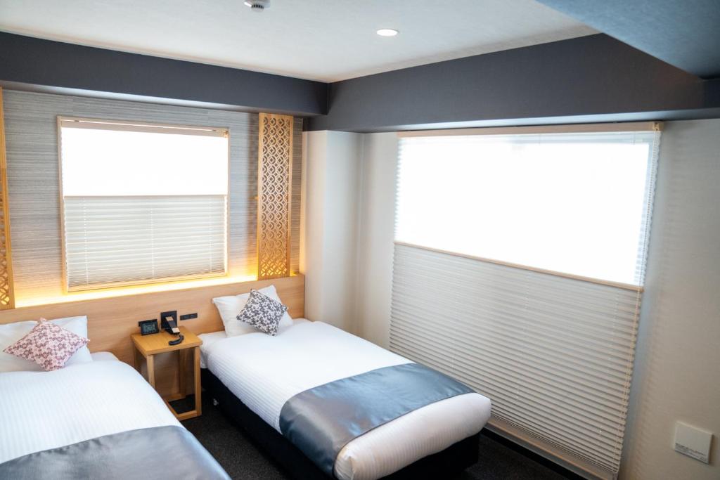 Postel nebo postele na pokoji v ubytování Tabist kiki HOTEL KYOTO Gojo Karasuma