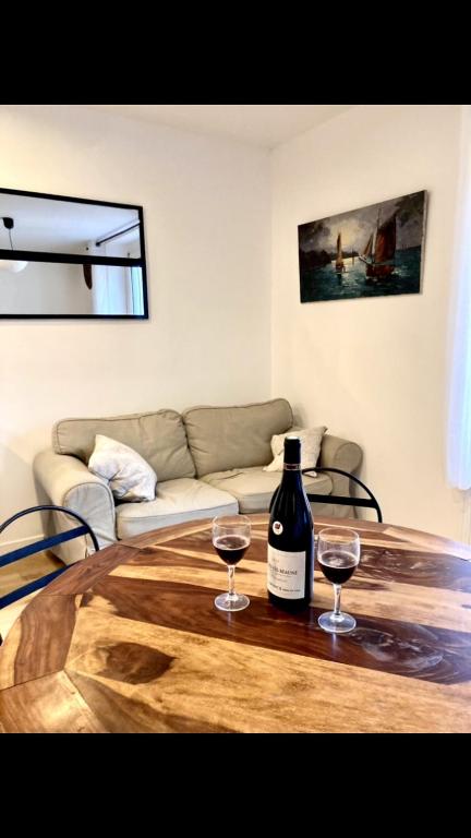 - une bouteille de vin et deux verres sur une table en bois dans l'établissement La sérénité côtière, à Dinard