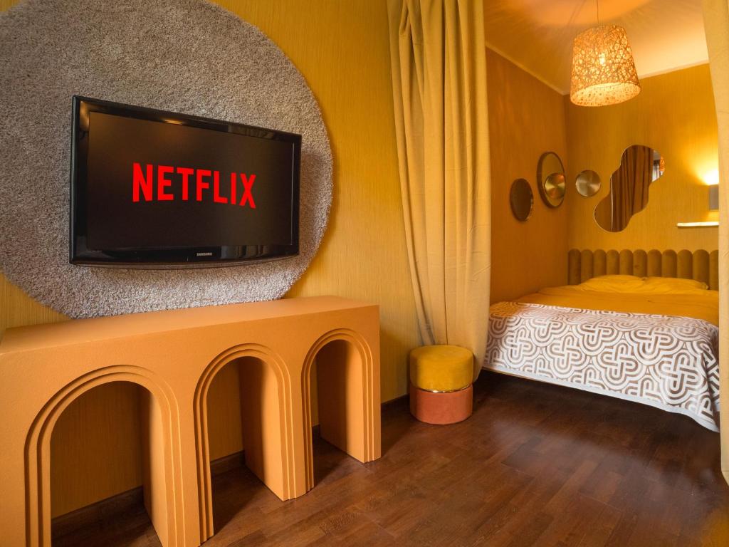 een hotelkamer met een tv en een bed bij Midcentury modern, quiet, 40m studio with bath in Rīga