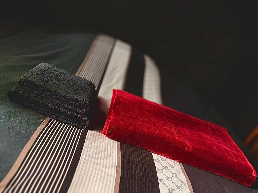 a pair of red and black ties sitting on a bed at THE BLACKTAGON Cozy Room in Frankfurt/Main