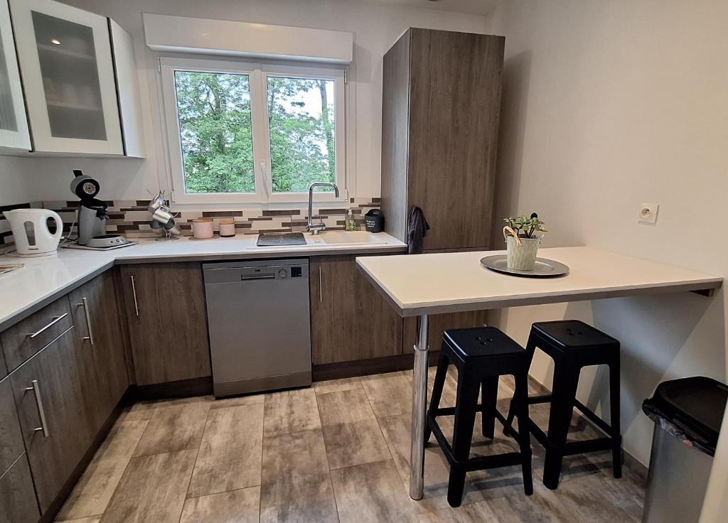 - une cuisine avec un évier, une table et deux tabourets dans l'établissement maison agréable avec terrasse, à Joinville