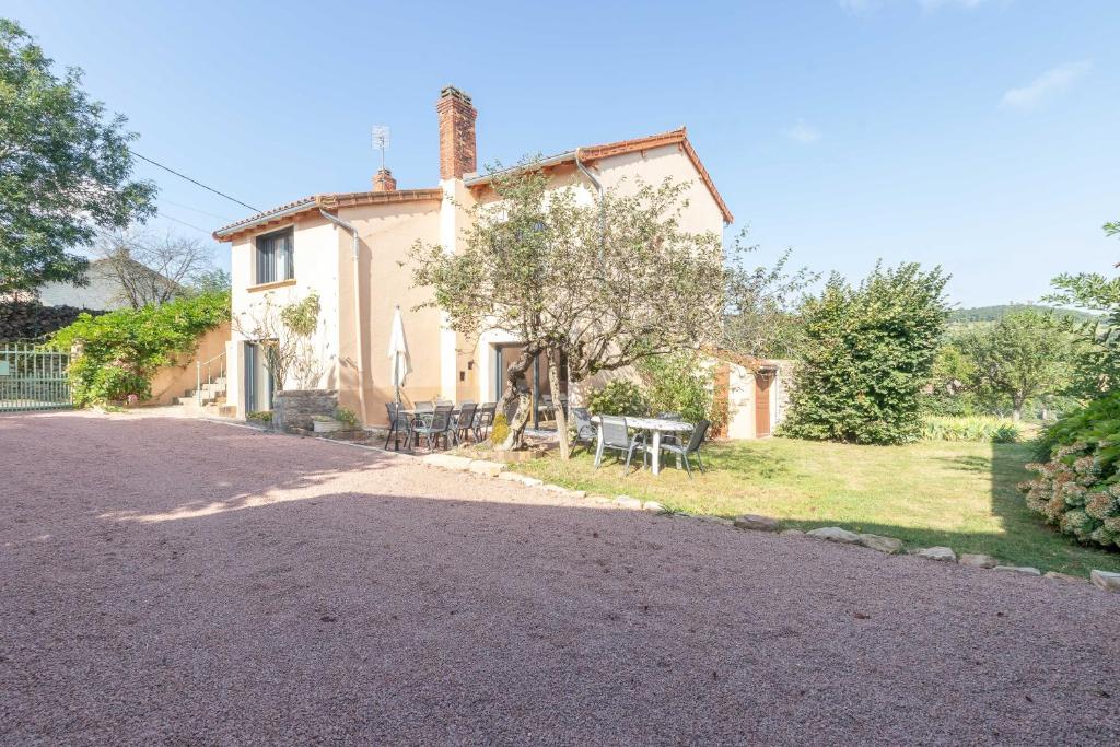 une maison avec une table et un banc devant elle dans l'établissement Cabana & Maison sur les hauteurs - Proche Cluny, à Jalogny