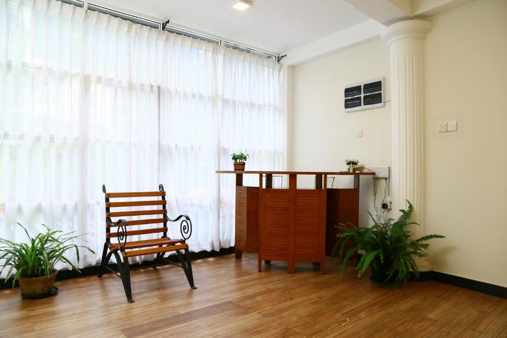 a room with a bench and a large window at City Nest Inn in Kandy