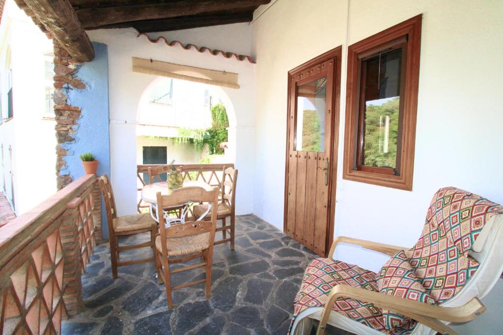 a porch of a house with chairs and a door at Casa Garalp - Only Adults by SIERRA VIVA in Aracena