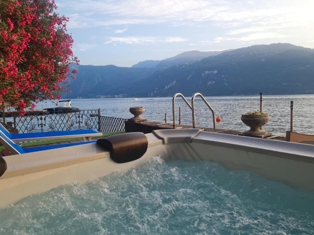 a swimming pool next to a body of water at Villa Meridiana-Luxury Lakeside Oasis on Lake Como in Lierna