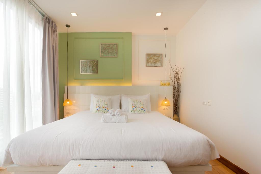 a bedroom with a large white bed with two pillows at Cozy room near Night bazaar in Chiang Mai