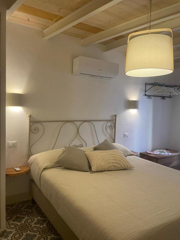 a bedroom with a large bed with a white headboard at Torre Anna Red in Riomaggiore