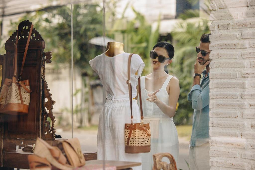 a man and a woman standing next to a store window at Holiday Inn Resort Bali Canggu by IHG in Canggu