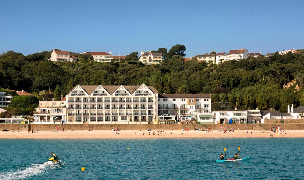 Les gens sont sur un bateau dans l'eau près d'une plage dans l'établissement Golden Sands, à Saint-Brélade