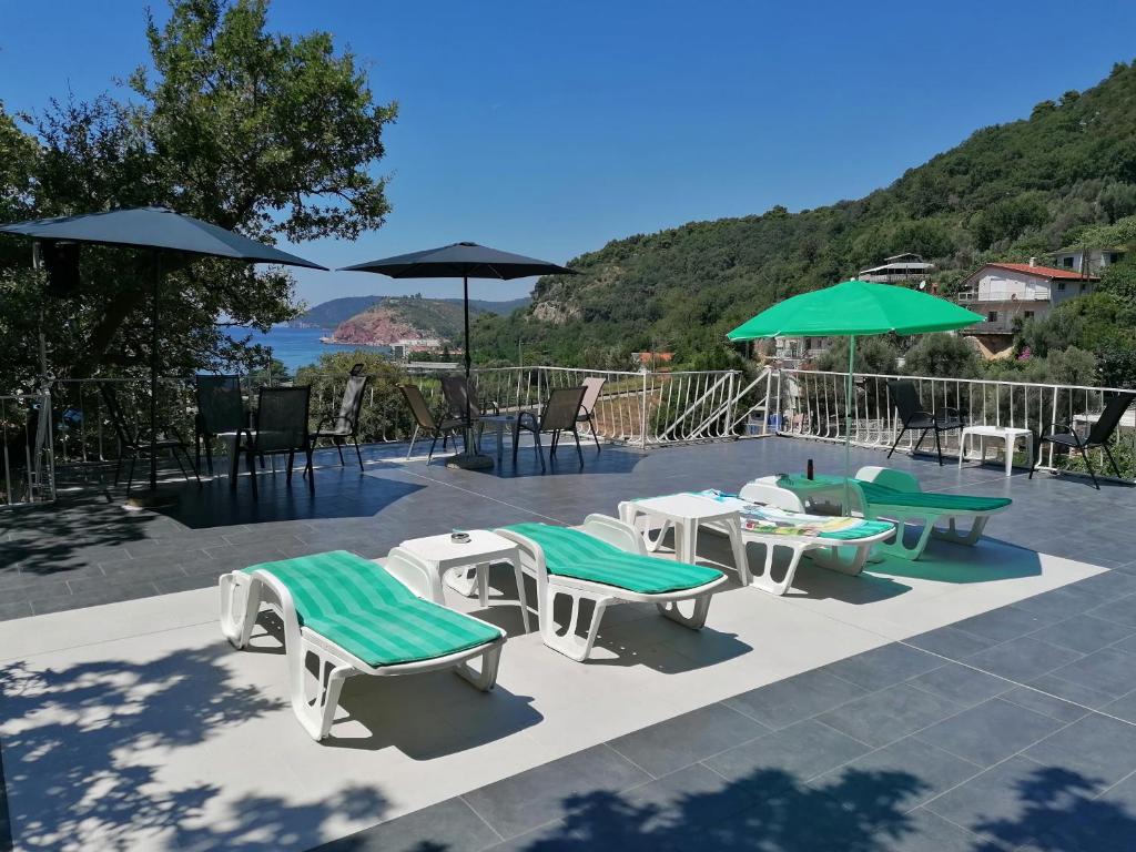 a group of tables and chairs with umbrellas at Apartmani Lav in Sutomore