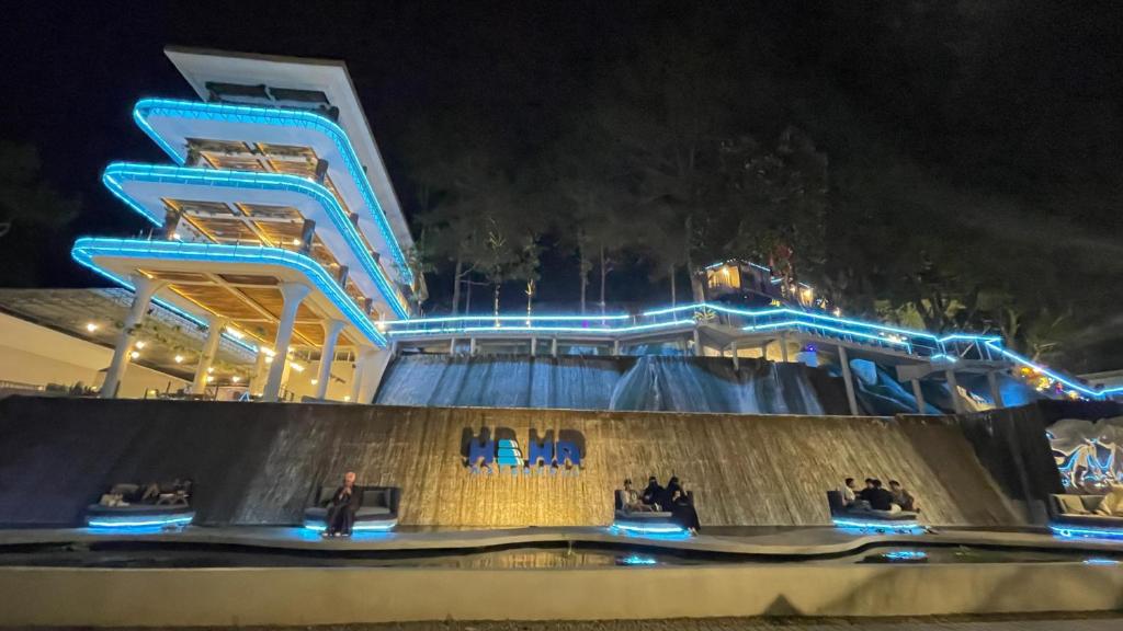 a water park with a roller coaster at night at HeHa Waterfall Suites & Camping Ground in Paragajen