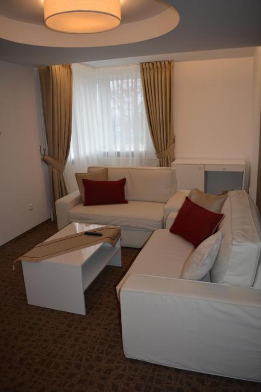 sala de estar con sofá blanco y almohadas rojas en Mokomasis svetingumo centras, en Utena