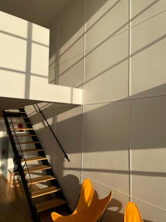 - un escalier avec des chaises orange dans la chambre dans l'établissement Duplex Le Corbusier, à Marseille