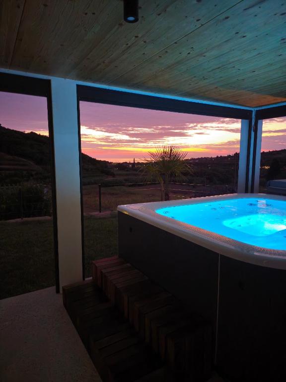 a hot tub in a house with a sunset in the background at SeaView apartment Mirjam with Jacuzzi in Portorož