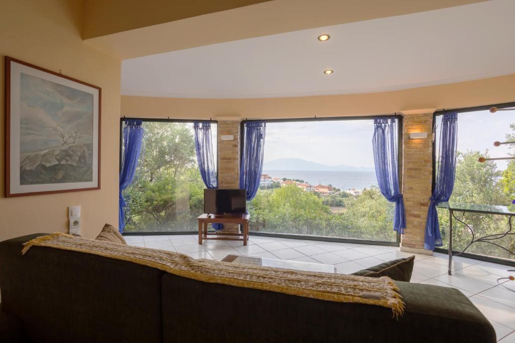 a living room with a couch and large windows at One Bedroom Villa in Alikanas