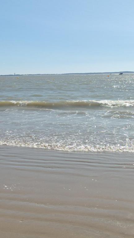 une plage de sable avec des vagues dans l'océan dans l'établissement appart studio-F1 Montpellier de Medillan -Royan 38 euros la nuit, à Montpellier-de-Médillan